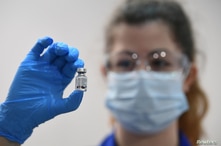 FILE - A member of medical staff holds a phial of the Pfizer/BioNTech COVID-19 vaccine jab, at Guy's Hospital, on the first day of the largest immunisation programme in the British history, in London, Britain, Dec. 8, 2020.