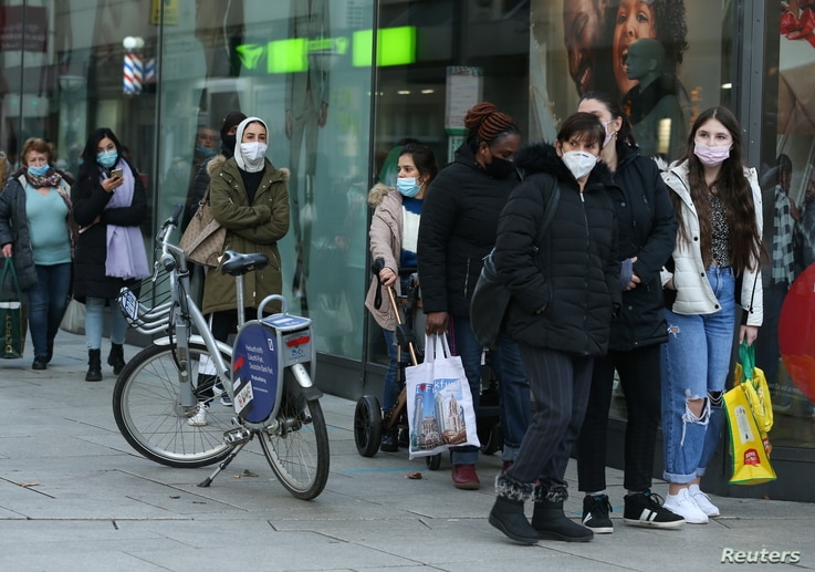 People queue in front of a shop, as the coronavirus disease (COVID-19) outbreak continues, in Frankfurt, Germany December 14,…