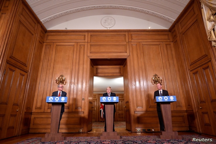 Britain's PM Boris Johnson attends a news conference, together with Chris Whitty, the Chief Medical Officer and Patrick Vallance, UK Gov. Chief Scientific Adviser, in response to the ongoing situation with the coronavirus, London , Dec. 19, 2020.