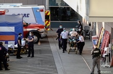 Paramedics escort a patient from the ambulance entrance to the emergency room at LAC + USC Medical Center during a surge of…