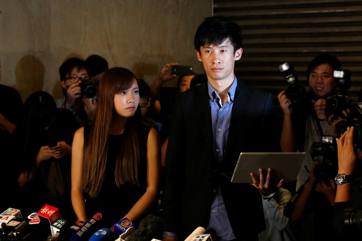 Democratically elected legislators Yau Wai-ching, left, and Baggio Leung meet journalists outside the High Court after the court disqualified them from taking office as lawmakers in Hong Kong, Nov. 15, 2016.