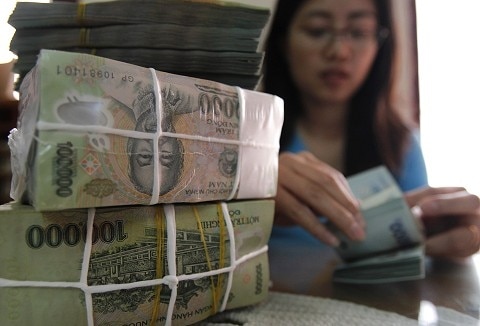 A woman counts Vietnamese dong bank notes in the office of a local company in Hanoi (File)