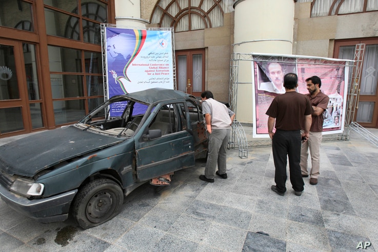 A man looks into the damaged car of Masoud Ali Mohammadi, an Iranian nuclear physics professor, who was killed in a bomb attack…