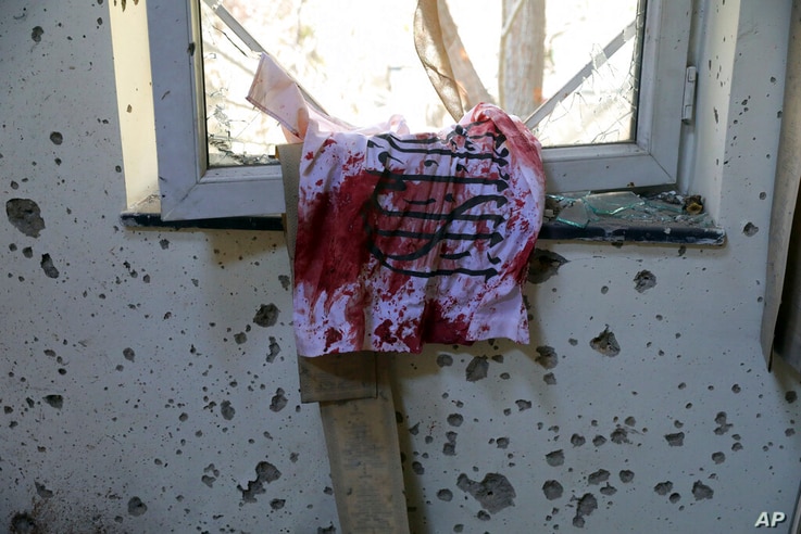 A blood-stained Taliban flag is seen on the window inside the Kabul University after a deadly attack in Kabul, Afghanistan,…