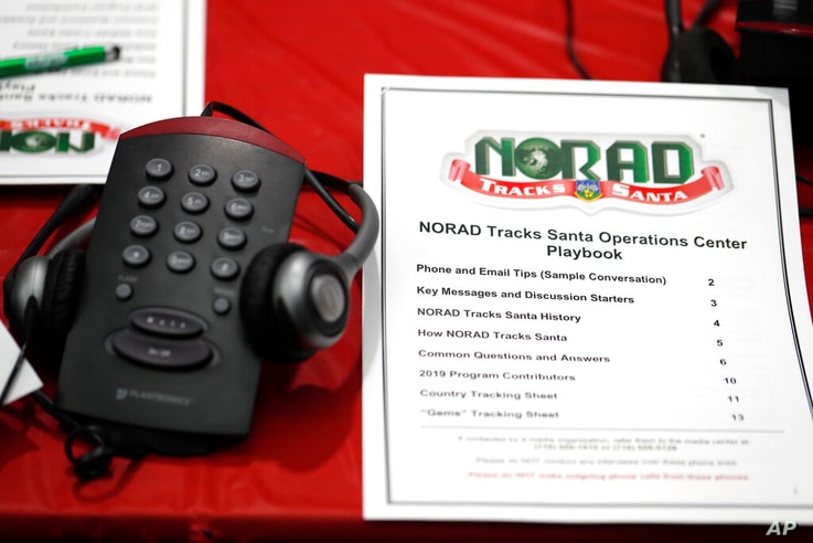 FILE - In this Dec. 23, 2019, file photo a playbook sits next to a telephone set up in the NORAD Tracks Santa center at…