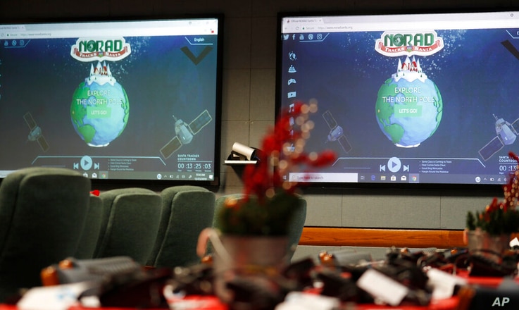 FILE - In this Dec. 23, 2019, file photo monitors are illuminated in the NORAD Tracks Santa center at Peterson Air Force Base…