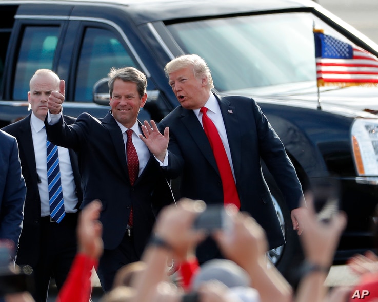 FILE - Then-Georgia Republican gubernatorial candidate Brian Kemp, left, walks with President Trump