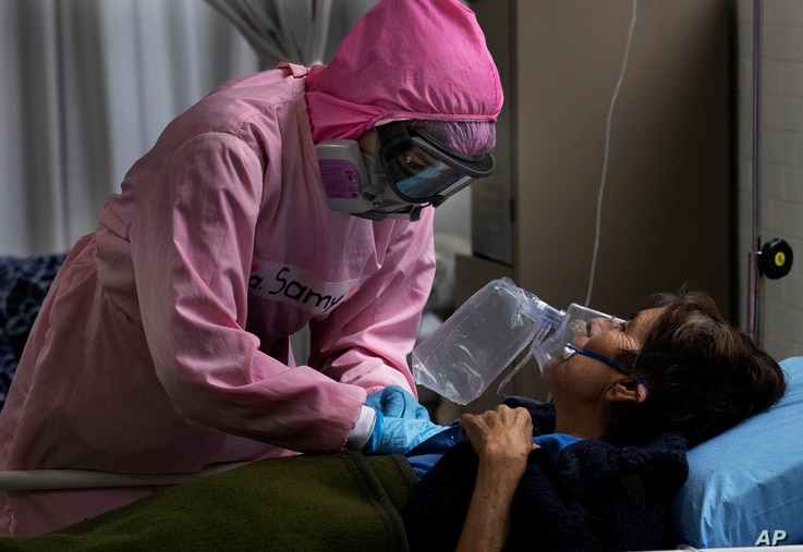 Dressed in protective gear to curb the spread of the new coronavirus, a medical worker massages a patient, at a military…
