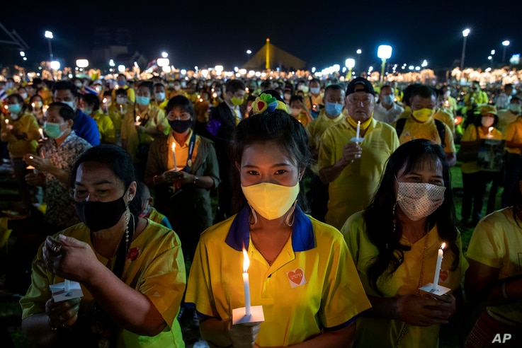 Supporters of the monarchy participate in a candle lighting ceremony to mark the anniversary of the birth of late King Bhumibol…