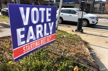 A sign in an Atlanta neighborhood on Friday, Dec. 11, 2020, urges people to vote early in Georgia's two U.S. Senate races. The…