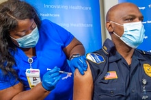 Lt. Ollie Martin, right, with Ochsner Security, is inoculated with the Pfizer-BioNTech COVID-19 vaccine by nurse Meshoca…