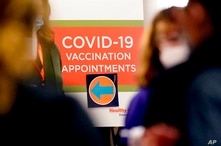 A COVID-19 vaccination appointments sign points the way at Edward Hospital in Naperville, Ill., Thursday, Dec. 17, 2020. Illinois…