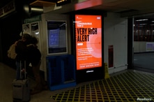 A digital sign shows that London is under coronavirus Tier 3 restrictions, the toughest level in England's three-tier system, at Euston railway station in London, Dec. 18, 2020.
