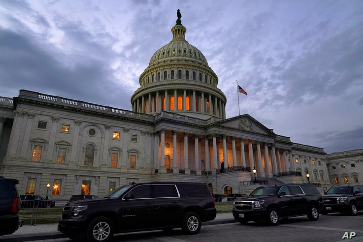 Dusk falls over the Capitol, Monday, Dec. 21, 2020, in Washington. Congressional leaders have hashed out a massive, year-end…