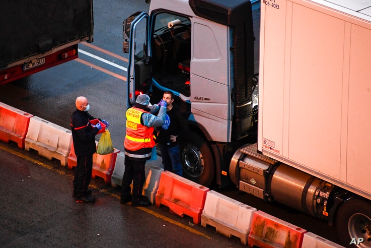 French officers make a COVID-19 test to a truck driver in the Port of Dover in Dover, England, Thursday, Dec. 24, 2020. Freight…