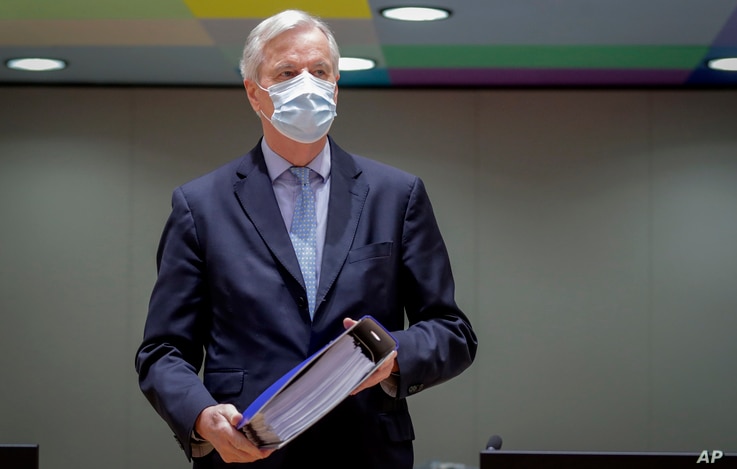 European Union chief negotiator Michel Barnier carries a binder of the Brexit trade deal during a special meeting of Coreper,…