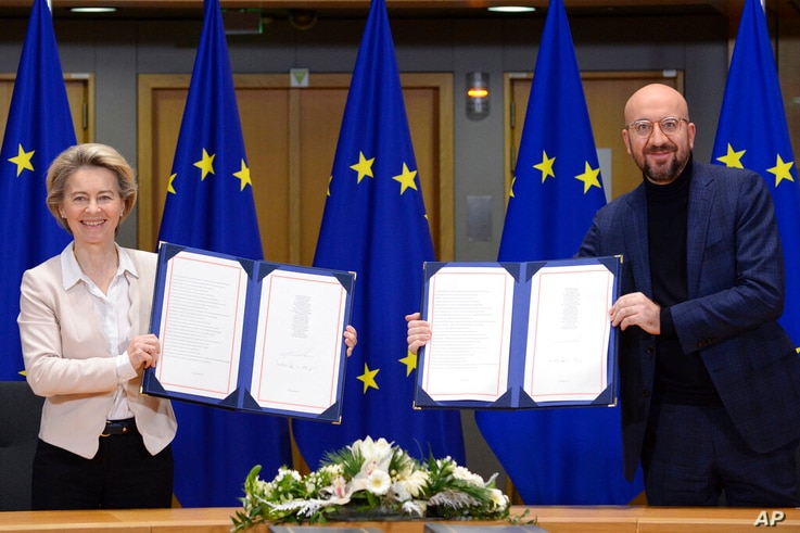 European Commission President Ursula von der Leyen, left, and European Council President Charles Michel show signed EU-UK Trade…