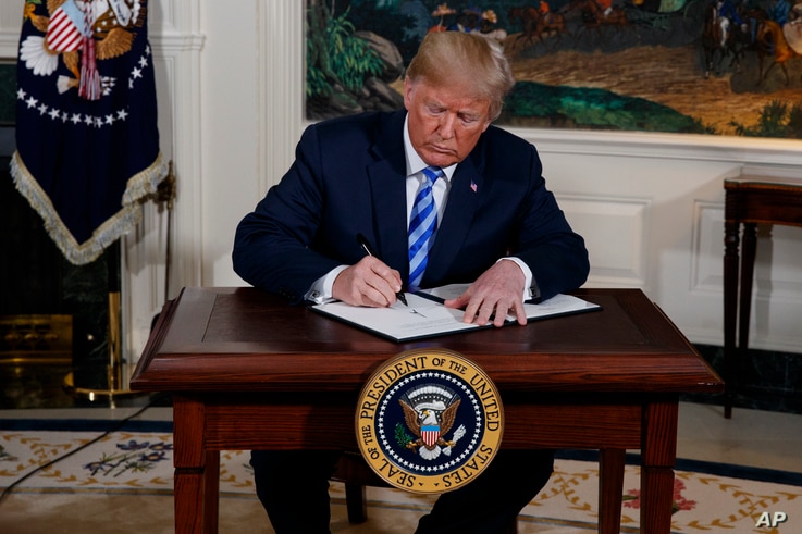 President Donald Trump signs a Presidential Memorandum on the Iran nuclear deal from the Diplomatic Reception Room of the White…