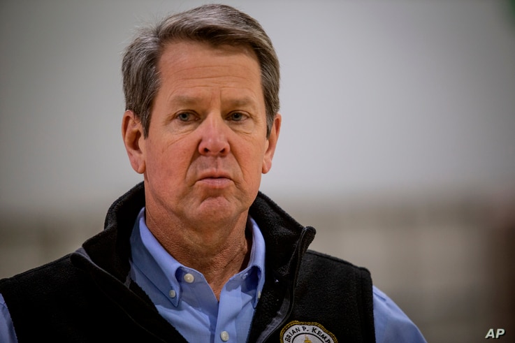Georgia Gov. Brian Kemp listens to a question from the press during a tour of a massive temporary hospital at the Georgia World…