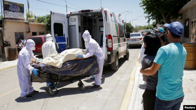 MEXICO – Paramedics transport the body of a man who died from COVID-19 in Ciudad Juarez, on May 26, 2020.