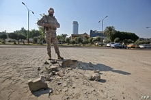 A member of the Iraqi security forces inspects the damage outside the Zawraa park in the capital Baghdad, Nov. 18, 2020, after volley of rockets slammed into the Iraqi capital breaking a month-long truce on attacks against the U.S. embassy.