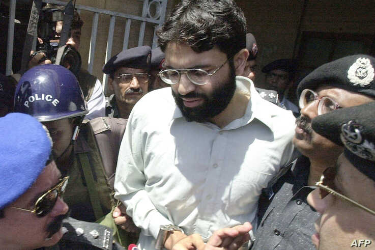 FILE - Pakistani police escort Ahmed Omar Saeed Sheikh, who was convicted in the 2002 killing of American journalist Daniel Pearl, as he exits a court in Karachi, Pakistan, March 29, 2002.