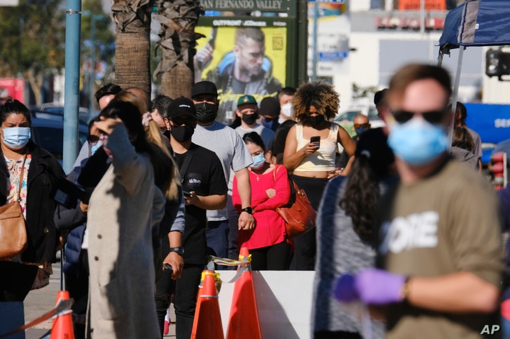 People wait in line to be tested at an outdoor COVID-19 testing site in the North Hollywood section of Los Angeles, California, Dec. 5, 2020.   