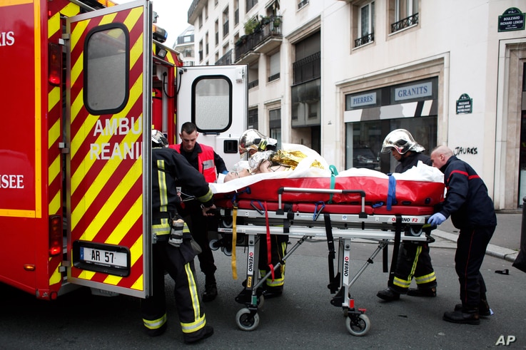 FILE - An injured person is transported to an ambulance after a shooting, at the French satirical newspaper Charlie Hebdo's office, in Paris, Jan. 7, 2015.