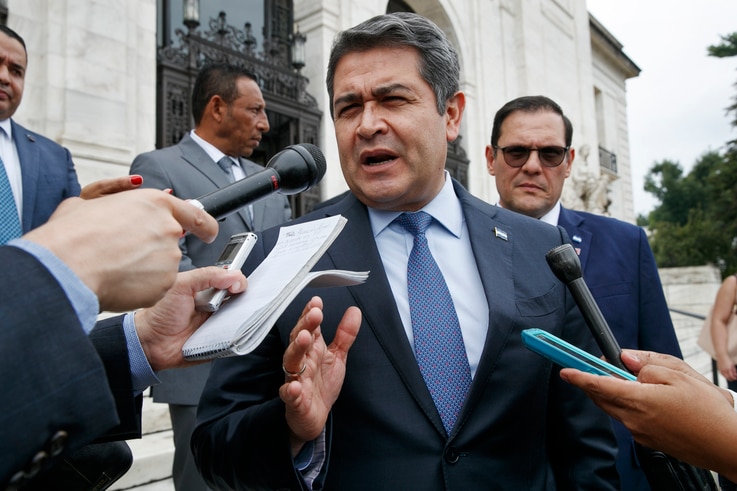 Honduran President Juan Orlando Hernandez answers questions from the Associated Press, Aug. 13, 2019, as he leaves a meeting at the Organization of American States, in Washington.