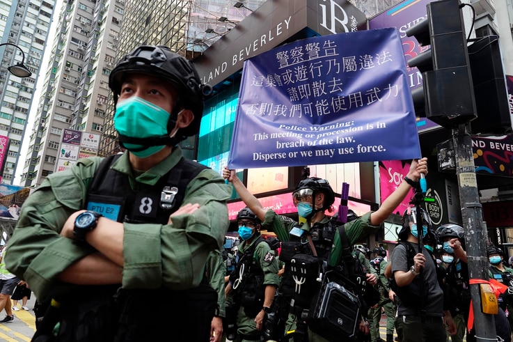 A police officer displays a warning banner on China's National Day in Causeway Bay, Hong Kong.