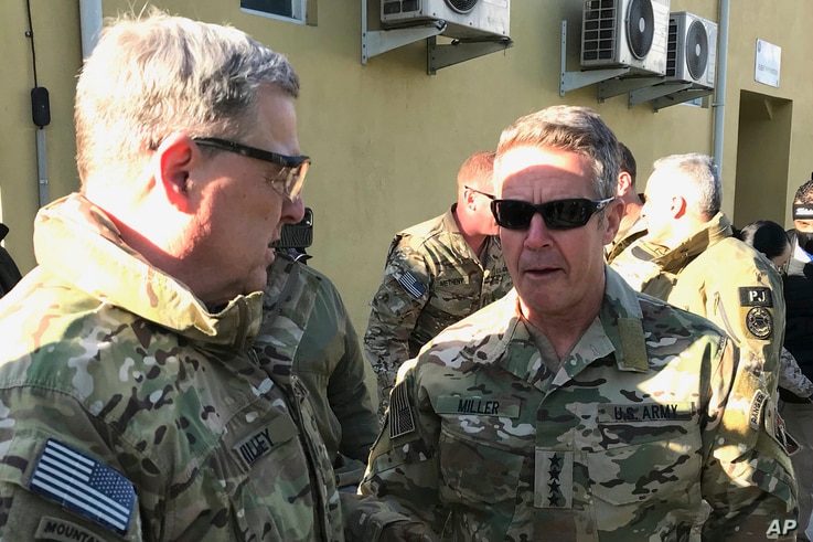 Chairman of the U.S. Joint Chiefs of Staff Gen. Mark Milley, left, talks with Gen. Scott Miller, the commander of U.S. and coalition forces in Afghanistan, Dec. 16, 2020, in Kabul, Afghanistan, before holding a meeting with Taliban peace negotiators.