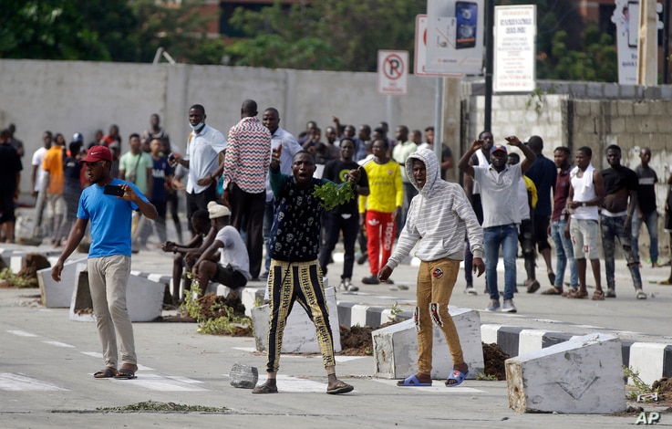 Young people protest at the Lekki toll gate in Lagos, Nigeria, Oct. 21, 2020. The Lekki toll gate was the site where demonstrators were fired upon earlier in the week in an escalation that sparked global outrage.