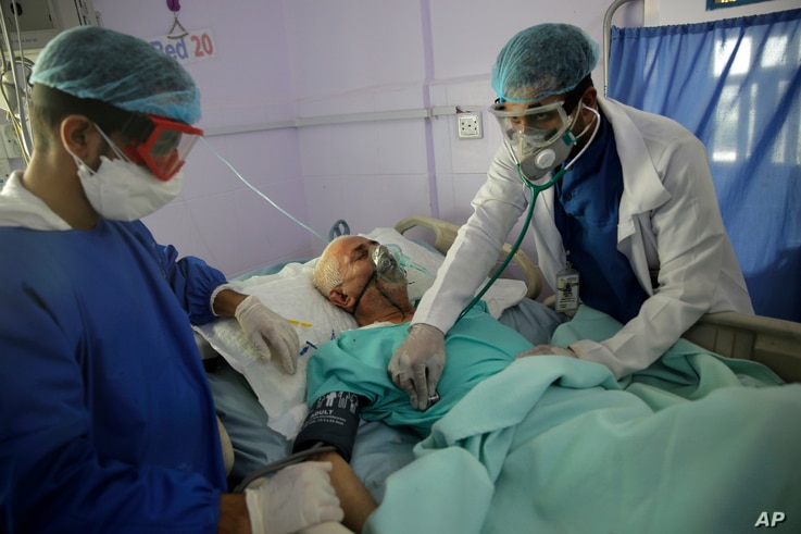 FILE - Medical workers attend to a COVID-19 patient in an intensive care unit at a hospital in Sana'a, Yemen, June 14, 2020.