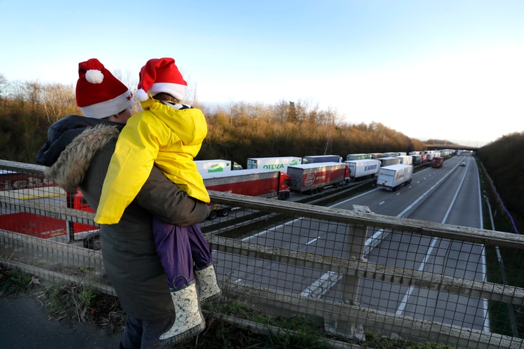 A mother and child look at the line of trucks parked up on the M20, part of Operation Stack in Ashford, Kent, England, Friday,…