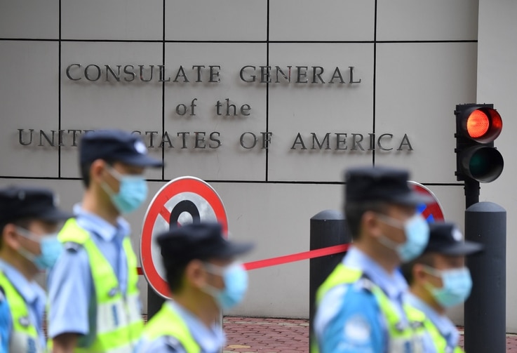Policemen walk past the US consulate in Chengdu, southwestern China's Sichuan province, on July 26, 2020. - Tensions have…