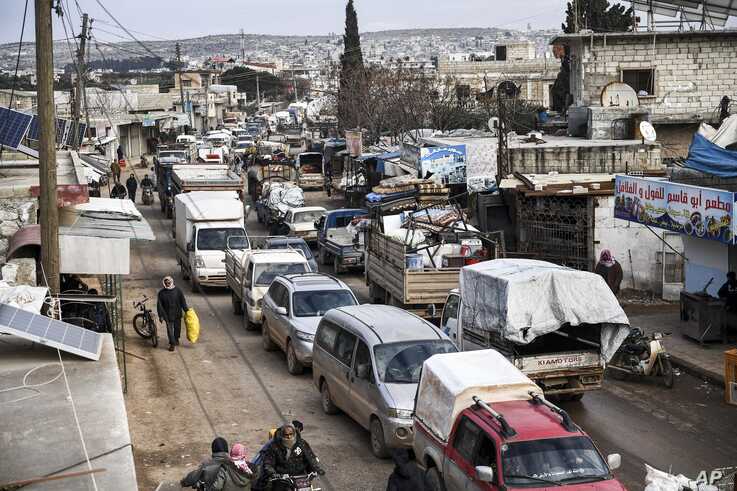 Civilians flee from Idlib toward the north to find safety inside Syria near the border with Turkey, Saturday, Feb. 15, 2020…