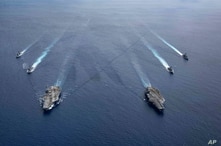 In this photo provided by U.S. Navy, the USS Ronald Reagan (CVN 76) and USS Nimitz (CVN 68) Carrier Strike Groups steam in…