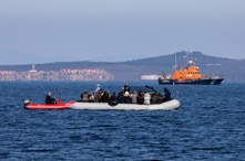 FILE - Migrants on a dinghy are approached by a Greek coast guard boat near the port of Thermi, as they crossed part of the Aegean Sea from Turkey to the island of Lesbos, Greece, March 1, 2020. 
