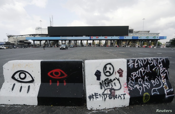 A road block with graffiti is seen at the Lekki toll gate, site of protests that turned deadly when security forces opened fire on demonstrators earlier this week, in Lagos, Nigeria, Oct. 24, 2020. 