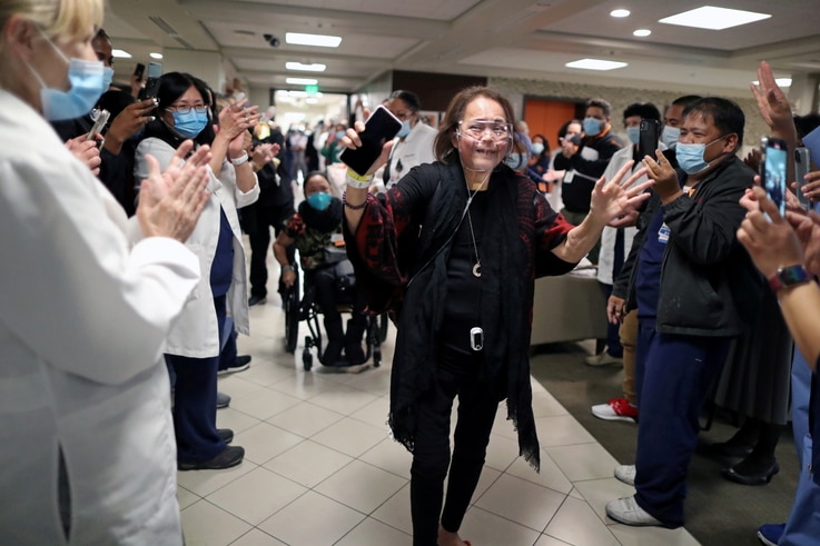Intensive Care Unit Nurse Merlin Pambuan, is cheered by hospital staff as she walks out of the hospital in Long Beach