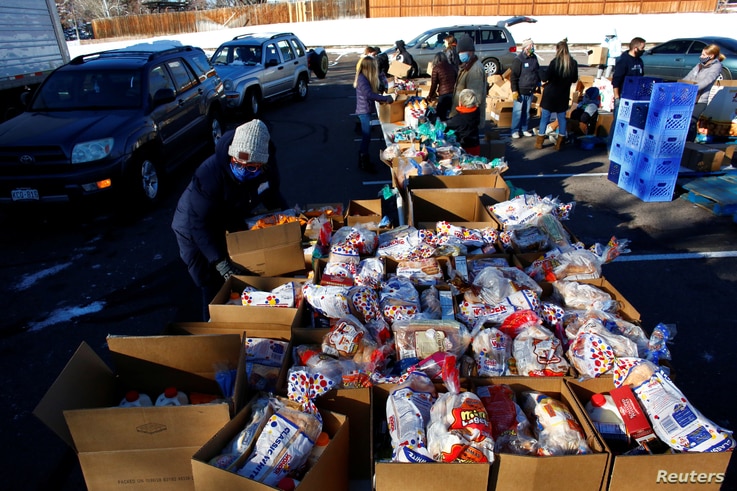 People line up in their cars in the parking lot of St. James Presbyterian Church in Littleton, Colorado, to receive food donations from Food Bank of the Rockies ahead of Thanksgiving, Nov. 25, 2020.