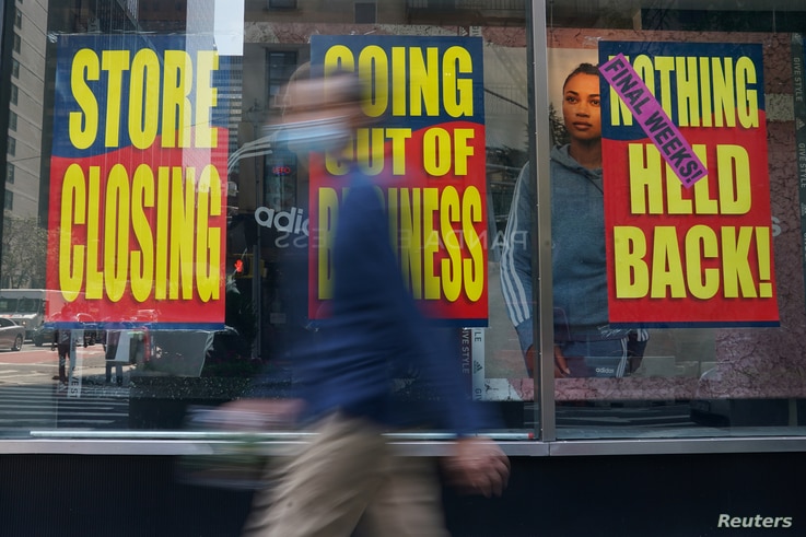 People walk past a business that is closing following the outbreak of COVID-19 in the Manhattan borough, New York, Aug. 17, 2020.