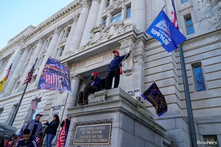 Supporters of U.S. President Donald Trump wave flags outside the D.C. Mayor's office building during the “Stop the Steal” rally, in Washington, Dec. 12, 2020.