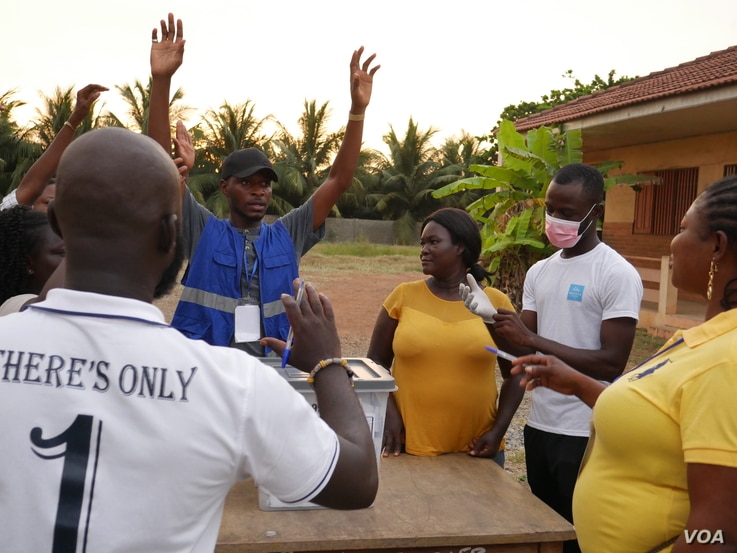 Election officials and observers start the process of vote counting on Dec 7 in Accra. (Stacey Knott/VOA)