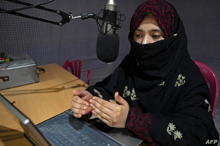 In this photo taken on September 29, 2020, radio presenter Shukria Wali, 18, reads the news during a broadcast at the Merman…
