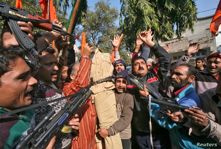 FILE - Supporters of Shiv Sena, a Hindu hardline group, shout slogans as they hold toy guns and an effigy depicting a Pakistani soldier during a protest in Jammu January 11, 2013.