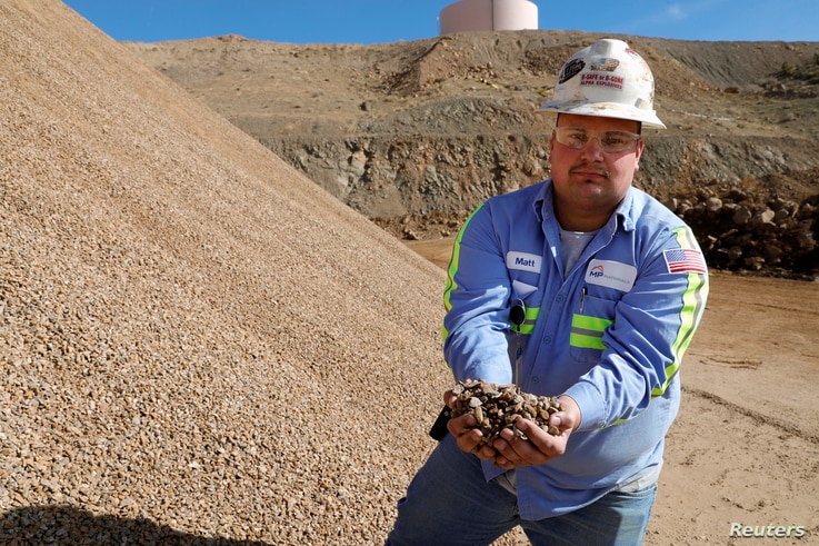 FILE - Matt Green, mining/crushing supervisor at MP Materials, displays crushed ore before it is sent to the mill at the MP Materials rare earth mine in Mountain Pass, California, Jan. 30, 2020.