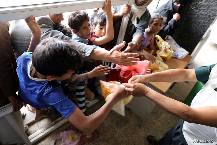 People crowd to get food rations from a charity kitchen in Sana'a, Yemen July 20, 2020. Picture taken July 20, 2020. REUTERS…
