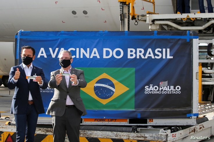 Brazil's Sao Paulo state Governor Joao Doria and state Health Secretary Jean Gorinchteyn hold boxes of the China's Sinovac…