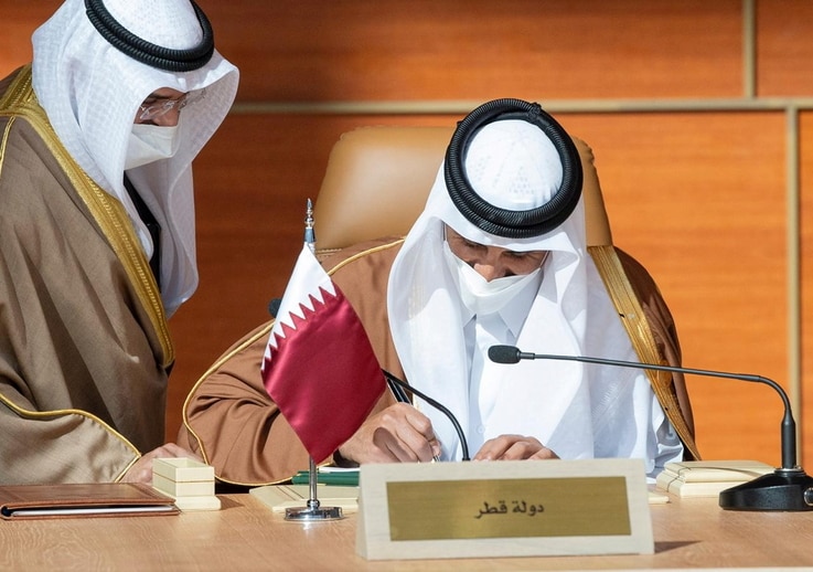 Qatar's Emir Sheikh Tamim bin Hamad al-Thani signs a document during the Gulf Cooperation Council's (GCC) 41st Summit in Al-Ula…